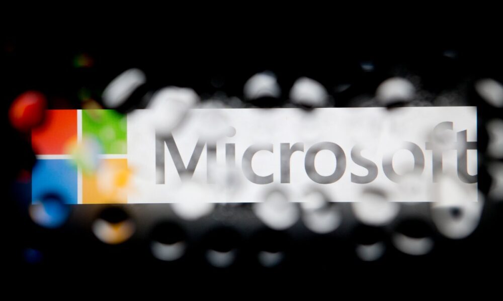 The Microsoft Corp. logo is seen through water droplets.