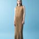 a model in a brown A-line dress against a blue background