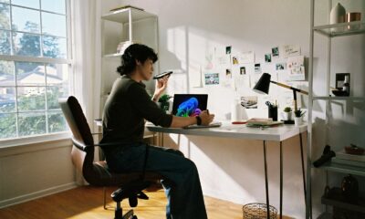 Person working at desk with laptop and phone.