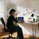Person working at desk with laptop and phone.